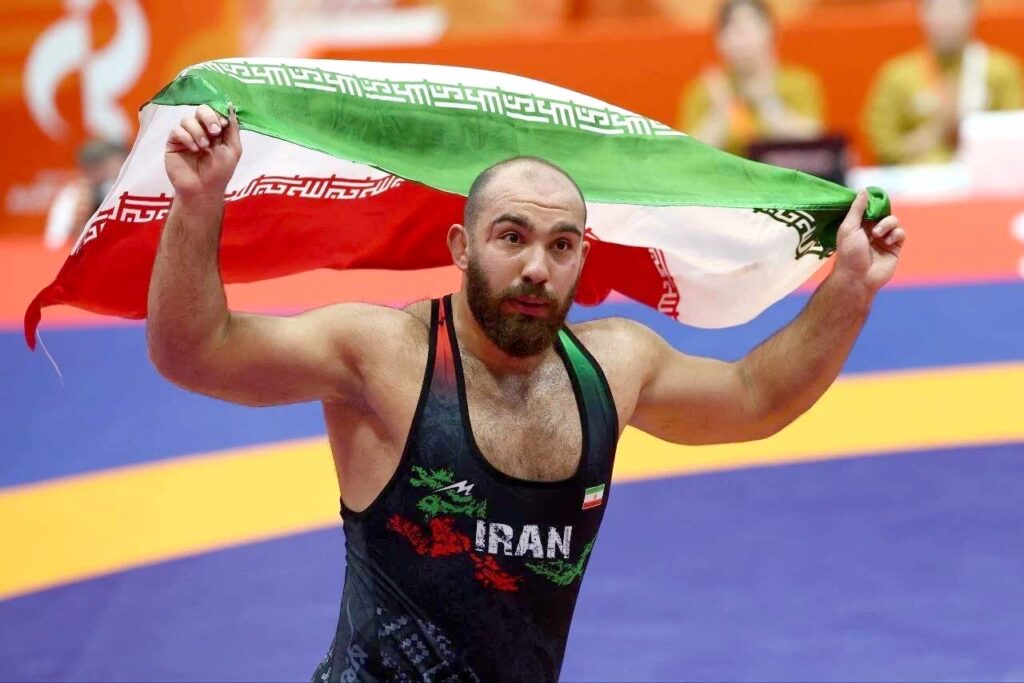 امیرحسین زارع در حال دور افتخار با پرچم ایران در بازی‌های آسیایی ناگویا ۲۰۲۶